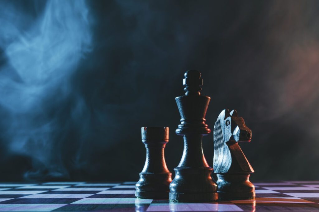 Chess pieces on a dark background 1 e1697913879398.jpg