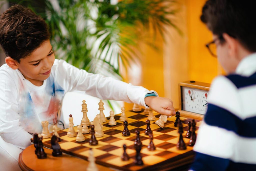 School boys playing chess e1698161918720.jpg