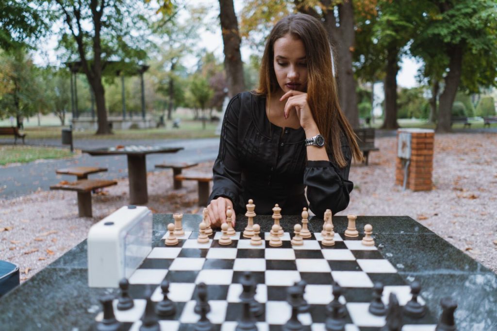 Young woman playing chess e1698161958214.jpg